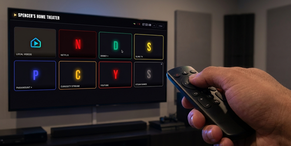 Hand holding air mouse remote pointed at TV displaying CinemaOS.